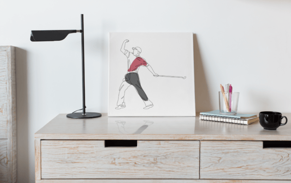 White wall canvas sitting on a desk of Tiger Woods fist pumping whilst holding putter