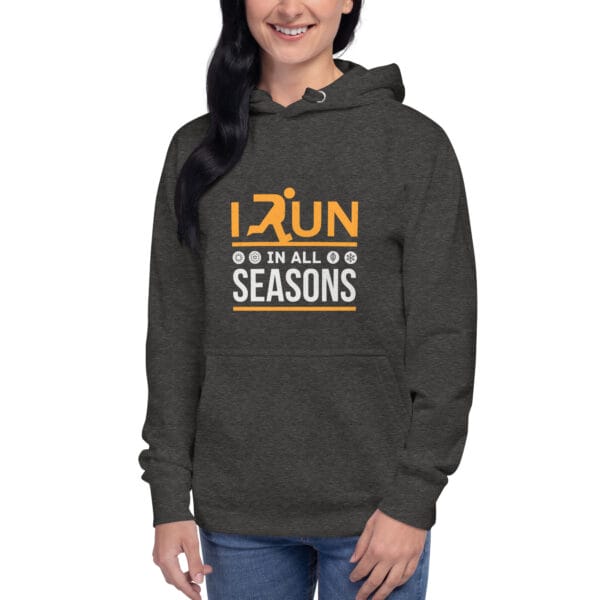 Young woman wearing premium hoodie in charcoal heather with text "I run in all seasons" with the letter R a silhouette of a runner