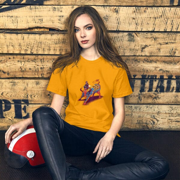 Young woman sat leaning against wall wearing gold t-shirt with max verstappen sat arms folded on top of a raging bull