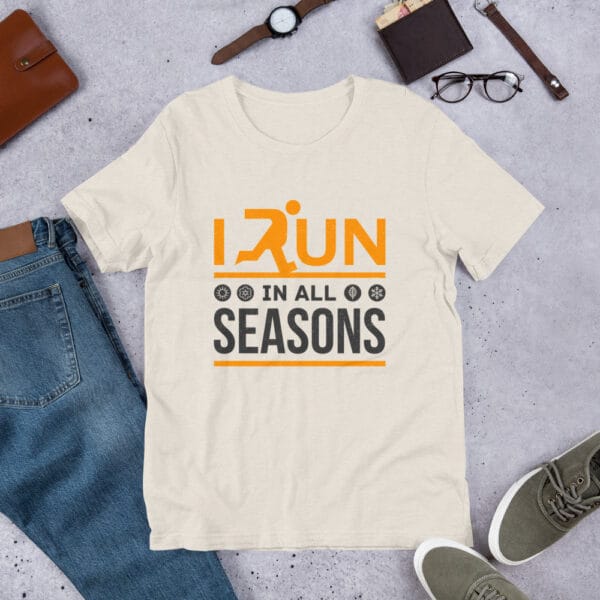 Unisex staple t-shirt in heather dust with text "I run in all seasons" with the letter R a silhouette of a runner