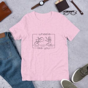 Unisex staple t-shirt in lilac with a bike and girl about to embrace with text "I wheelie like you"