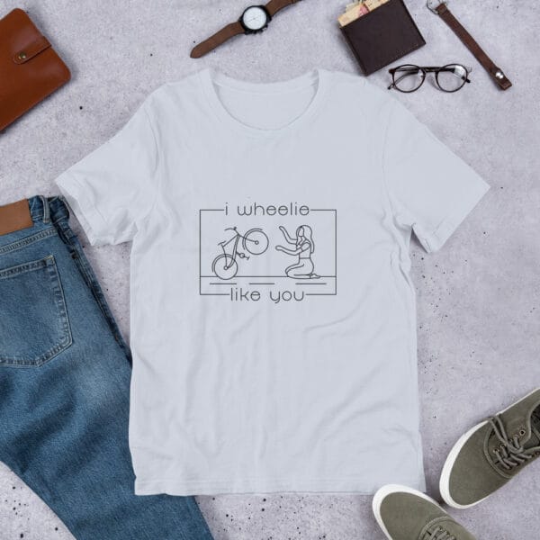 Unisex staple t-shirt in light blue with a bike and girl about to embrace with text "I wheelie like you"