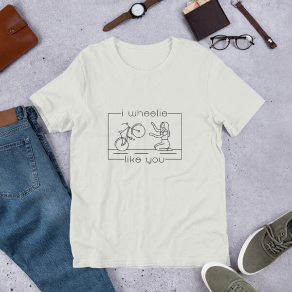 Unisex staple t-shirt in silver with a bike and girl about to embrace with text "I wheelie like you"