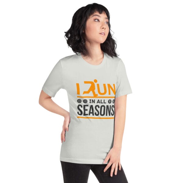 Young woman wearing a silver staple t-shirt with text "I run in all seasons" with the letter R a silhouette of a runner