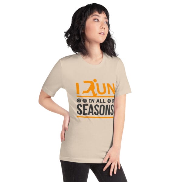 Young woman wearing a soft cream staple t-shirt with text "I run in all seasons" with the letter R a silhouette of a runner