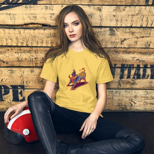 Young woman sat leaning against wall wearing yellow t-shirt with max verstappen sat arms folded on top of a raging bull