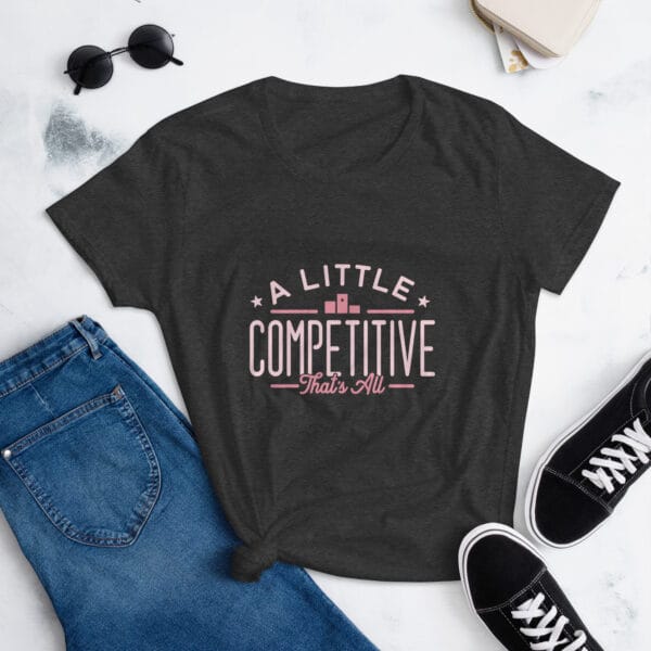 Women's short sleeve t-shirt in heather dark grey with pink text "A little competitive that's all" with two small stars