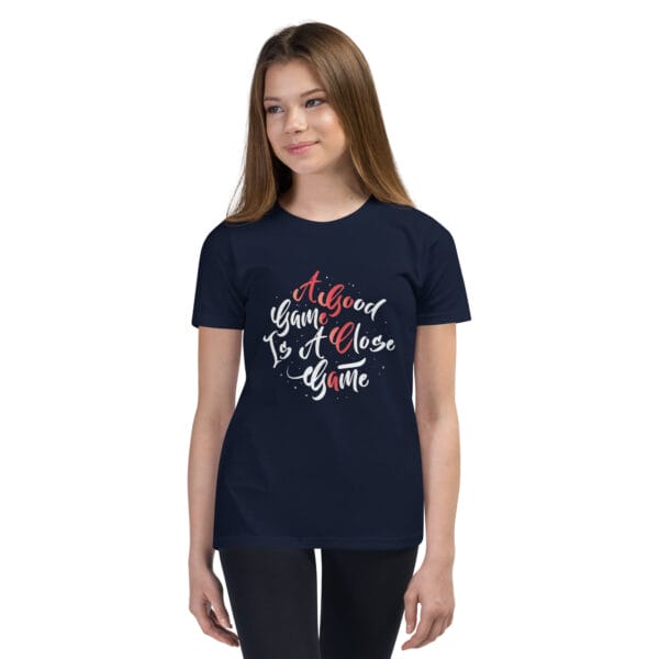 Young girl wearing navy youth staple t-shirt with text 'A good game is a close game'