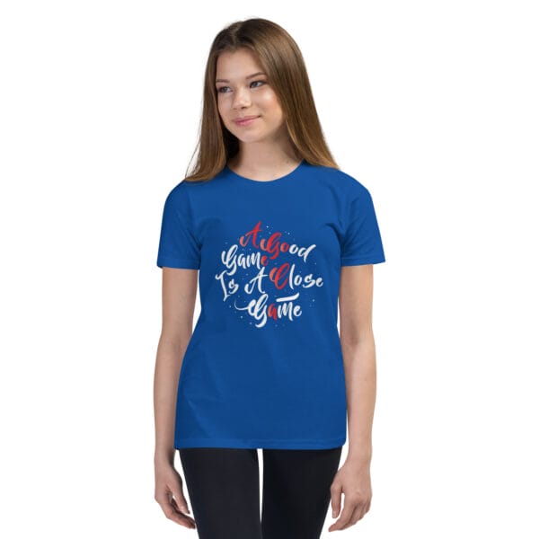 Young girl wearing royal blue youth staple t-shirt with text 'A good game is a close game'