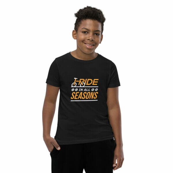 Young boy wearing a black staple t-shirt with text 'I ride in all seasons'