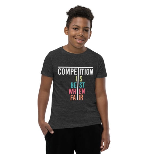 Young boy in dark grey heather staple t-shirt with text 'Competition is best when fair'