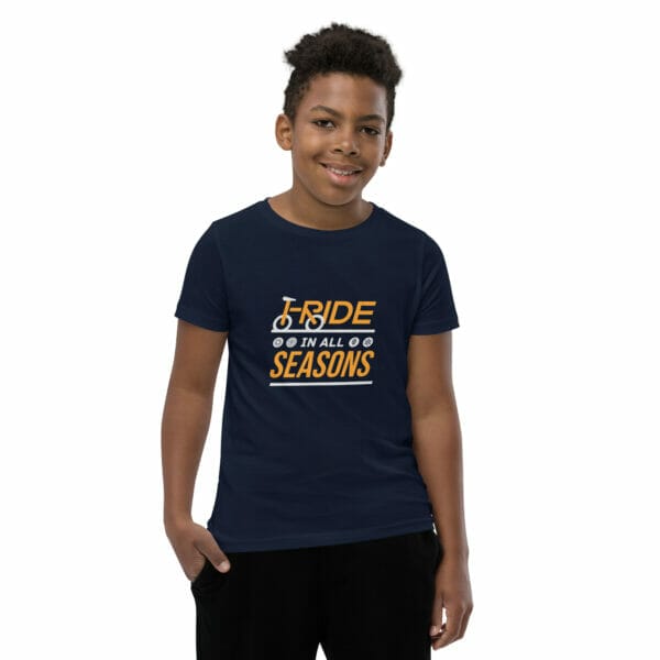 Young boy wearing a navy staple t-shirt with text 'I ride in all seasons'