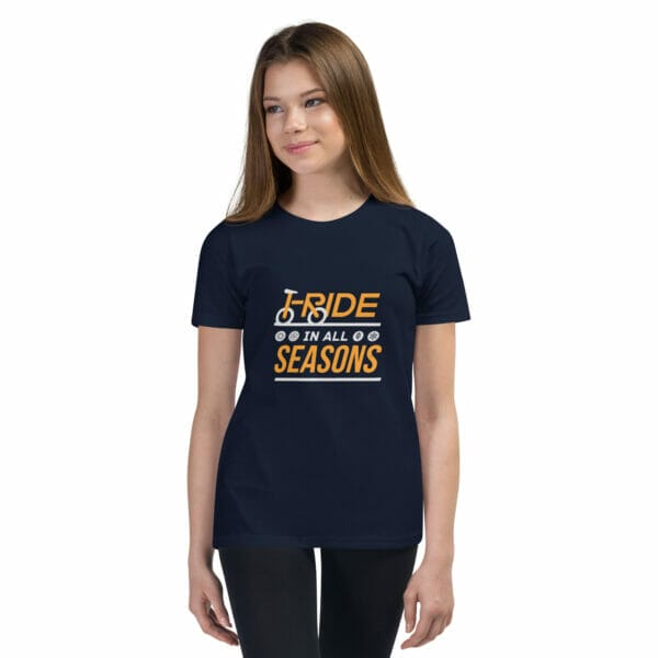 Young girl wearing a navy staple t-shirt with text 'I ride in all seasons'