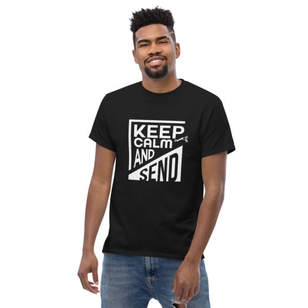 Man wearing a black classic t-shirt with white text 'Keep Calm and Send' with small biker doing a superman air