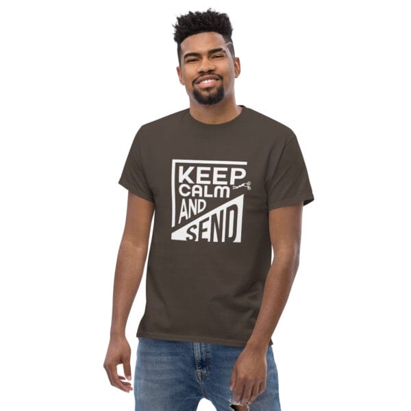 Man wearing a dark chocolate classic t-shirt with white text 'Keep Calm and Send' with small biker doing a superman air