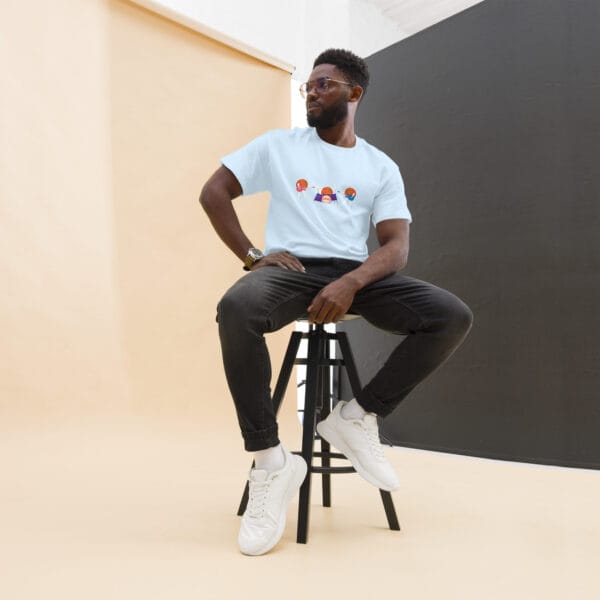 Man sitting down wearing a classic tee in light blue with three basketballs playing the guitar and drums