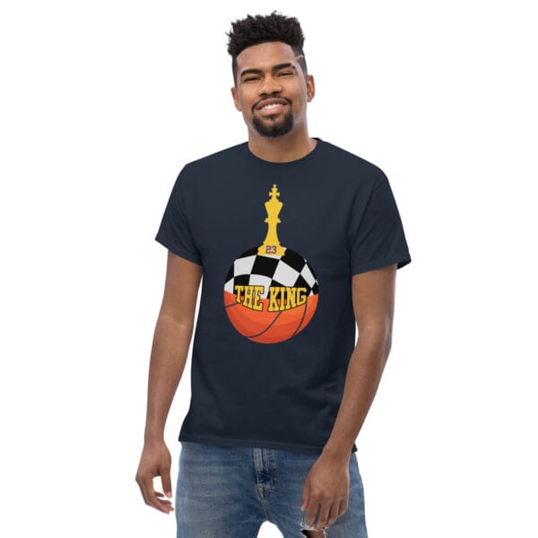 Man wearing classic tee in navy with text 'The King', a basketball with top half a chess board and King piece on top with number 23