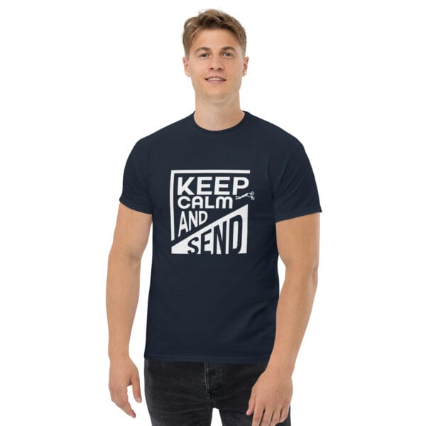 Man wearing a navy classic t-shirt with white text 'Keep Calm and Send' with small biker doing a superman air