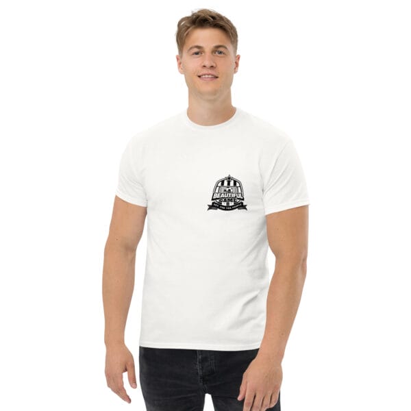 Man wearing a classic tee in white with small black the beautiful game crest on left side of chest