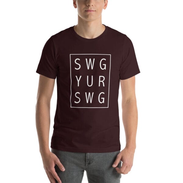 Man wearing oxblood black unisex staple t-shirt with text 'SWG YUR SWG' meaning swing your swing in a 3 by 3 box