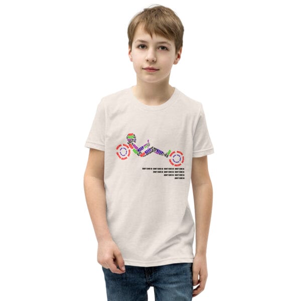 Boy in a staple tee in heather dust with text 'Keep racing' creating a racing driver and wheels