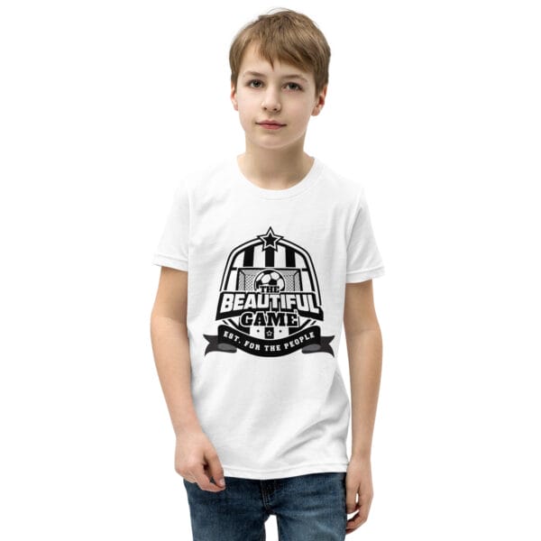 Boy in a white staple t-shirt with a black The Beautiful Game crest, est. for the people