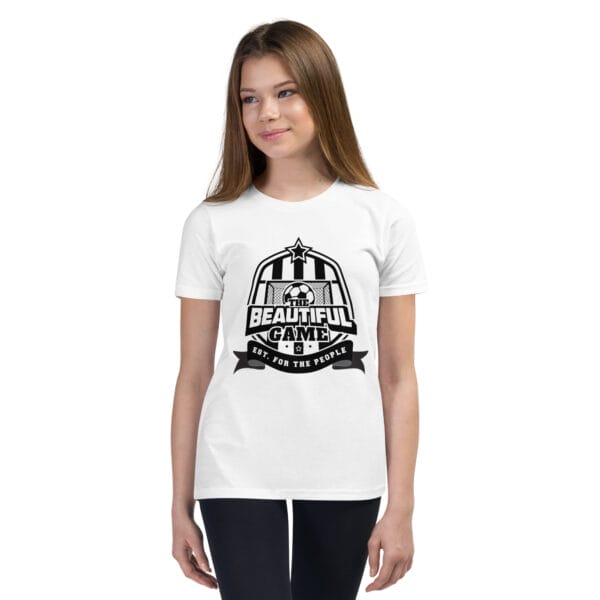 Girl in a white staple t-shirt with a black The Beautiful Game crest, est. for the people