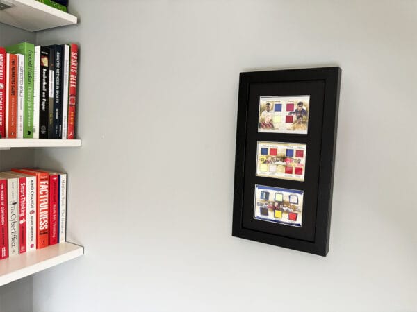 Football memorabilia display case hanging on wall, 18 game-worn relics, including Messi, Ronaldo, Haaland