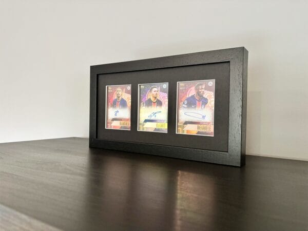 PSG memorabilia black display with Barcola, Ramos and Dembele autographs standing upright on black surface