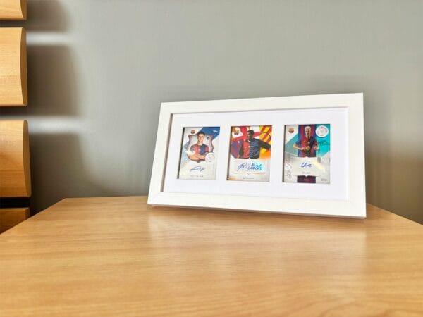 FC Barcelona memorabilia display, white frame, three signed sports cards from Victor, Rivaldo and Olmo, bedside table standing