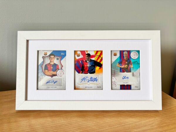 Barcelona 125th Anniversary memorabilia display, white frame, three signed sports cards from Victor, Rivaldo and Olmo, on bedside table