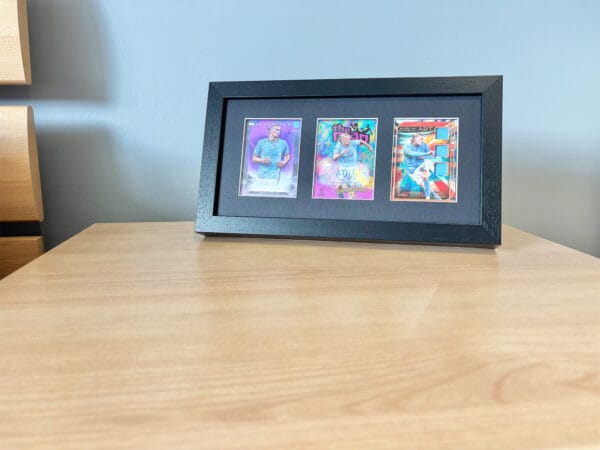 Erling Haaland autograph and relic display, black frame, standing on bedside table